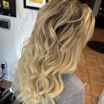 Bright blonde balayage with soft waves at Miracles Salon & Spa in Shallotte, NC